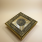 Decorative gold box with intricate designs on a beige background