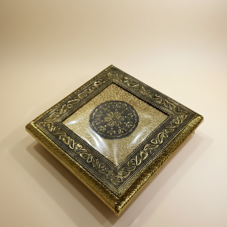 Decorative gold box with intricate designs on a beige background